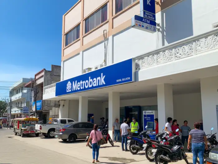 metrobank local branch best banks 2025 A candid, slightly low-angle shot of a busy Filipino street scene with various cars in the background and numerous pedestrians walking on the sidewalk.