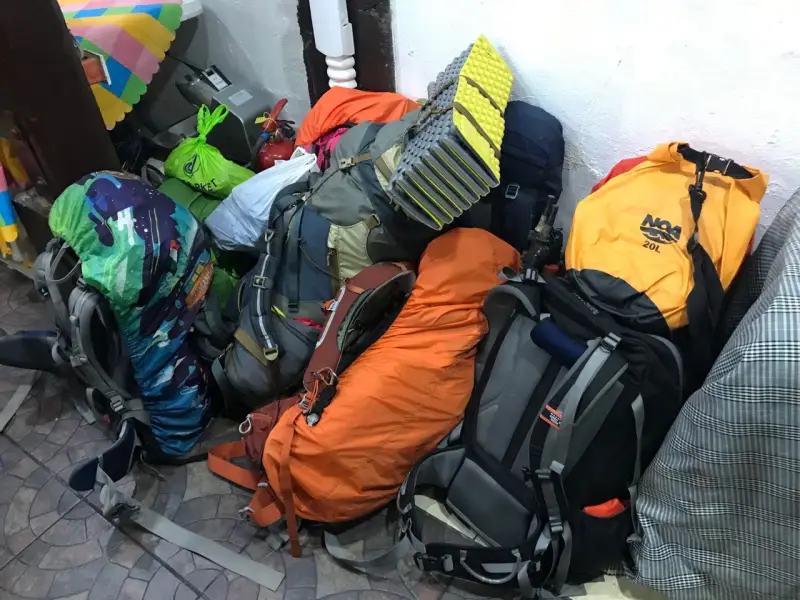 philippines hiking backpacks gear A pile of colorful hiking backpacks and gear stacked indoors, ready for a trip.