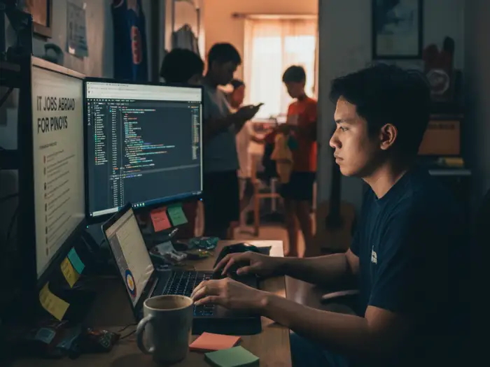 it jobs abroad pinoys filipino workers abroad Filipino IT worker coding at home while viewing IT jobs abroad for Pinoys