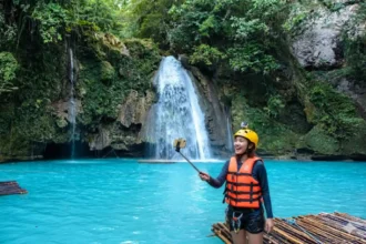 Filipina enjoying a selfie in the turquoise waters at Kawasan Falls in Badian, Cebu.