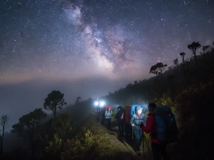 mount pulag overnight itinerary night hike Filipino hikers trekking with headlamps during an overnight climb to Mount Pulag summit.