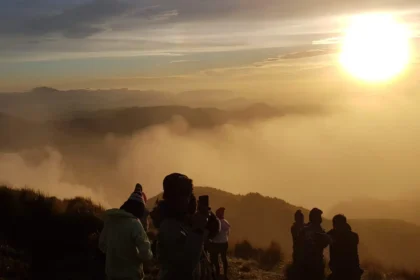 Filipino hikers enjoying the sunrise above the sea of clouds at Mount Pulag’s summit.